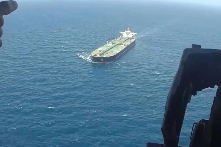US Navy warship intercepting cargo vessel in maritime blockade operation near Iran waters